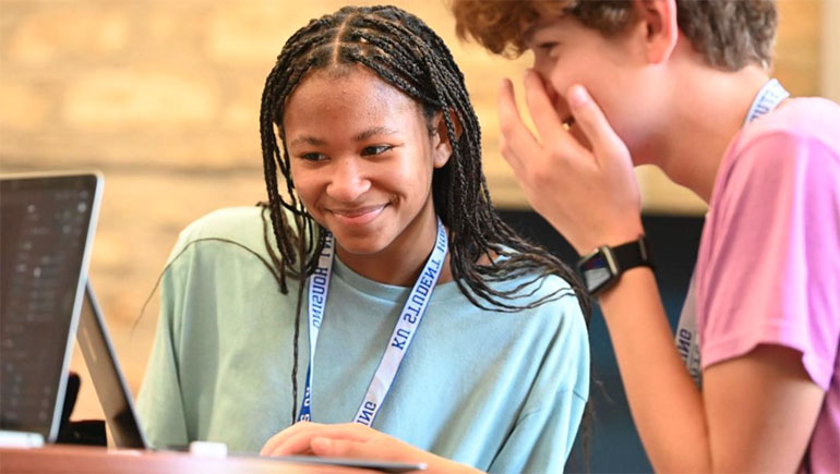 Two students looking at a laptop