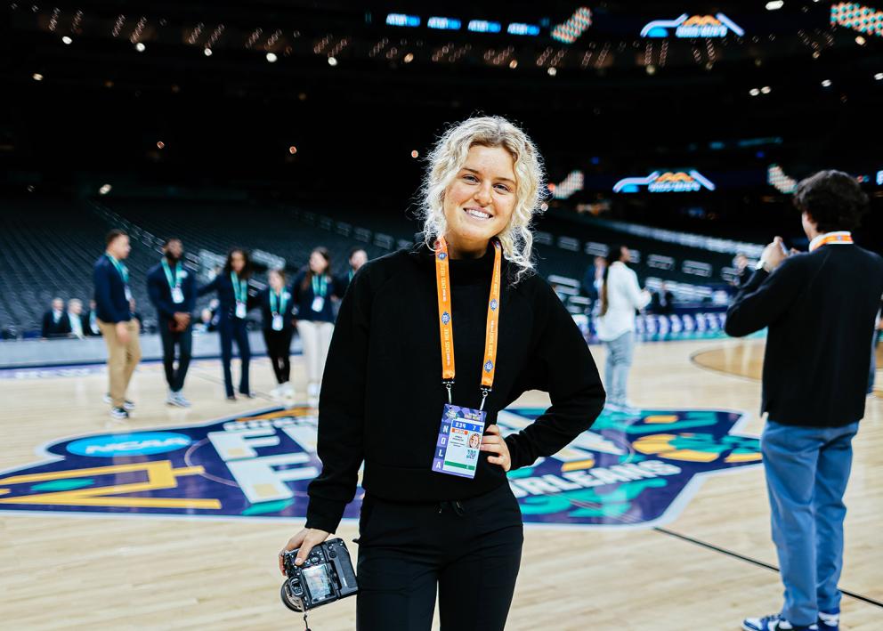 Emma Pravecek standing in front of the Final Four logo at mid-court in the Superdome in April 2022.